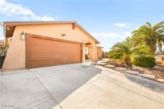 view of front of home featuring stucco siding, a garage, and concrete driveway