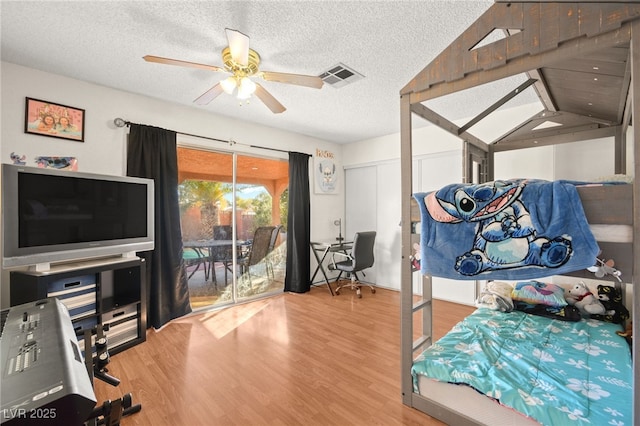 bedroom featuring wood finished floors, visible vents, ceiling fan, access to exterior, and a textured ceiling