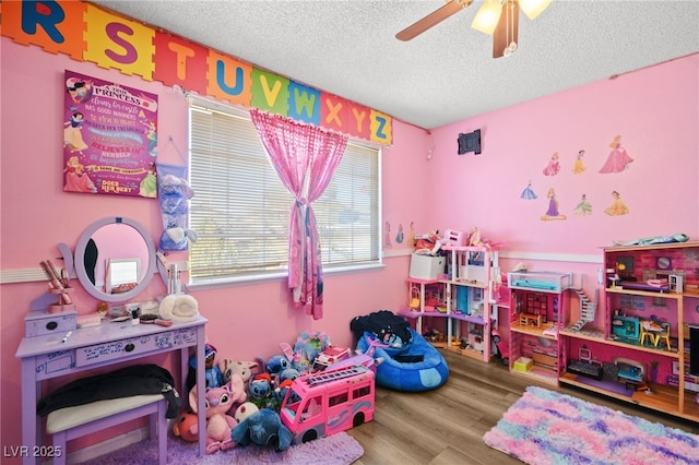 playroom featuring ceiling fan, a textured ceiling, and wood finished floors