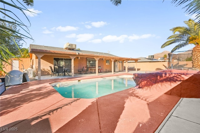 outdoor pool with outdoor dining space, a patio, central AC unit, and fence