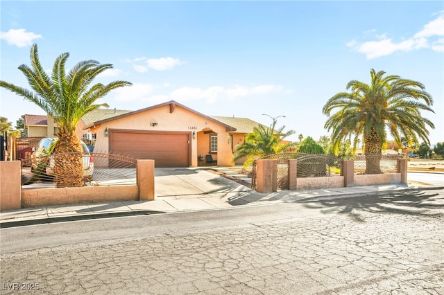 view of front facade with a fenced front yard, a garage, concrete driveway, and stucco siding