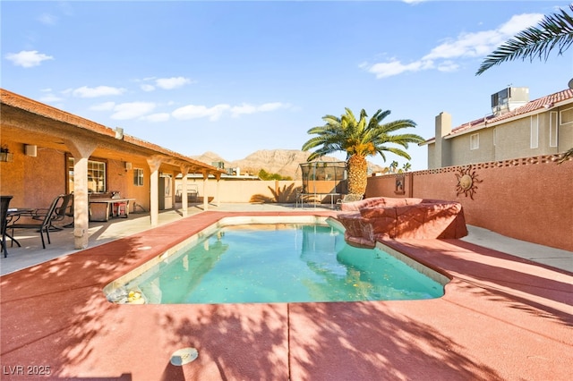 view of pool with a fenced in pool, cooling unit, a fenced backyard, a patio area, and a mountain view