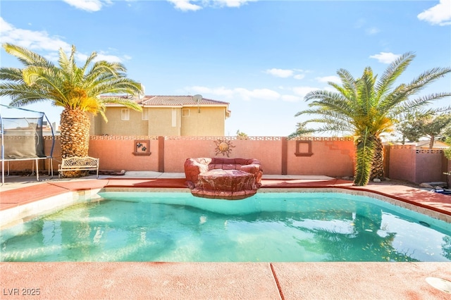 view of swimming pool with a fenced backyard, a patio area, a fenced in pool, and a trampoline