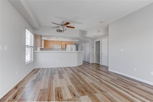 unfurnished living room featuring visible vents, ceiling fan, baseboards, and light wood-style floors