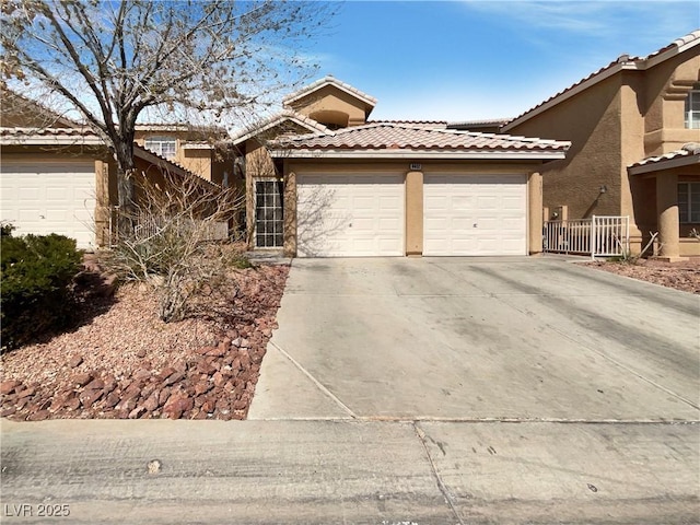 view of front of property with stucco siding, an attached garage, driveway, and a tile roof