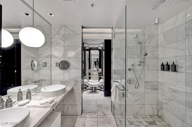 full bath featuring a sink, visible vents, a stall shower, and double vanity