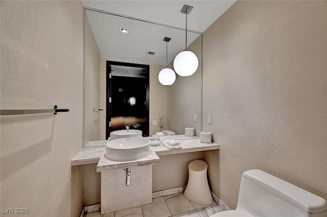 bathroom featuring a sink, visible vents, toilet, and tile patterned floors