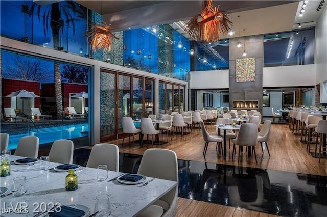 dining room featuring wood finished floors and a towering ceiling