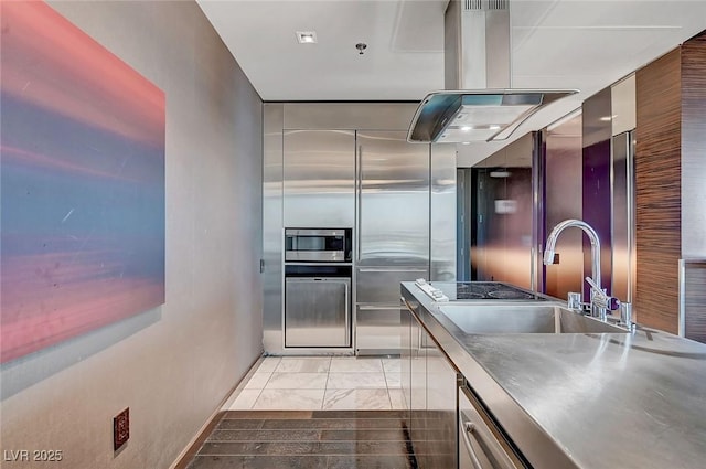 kitchen featuring modern cabinets, a sink, stainless steel counters, island range hood, and baseboards