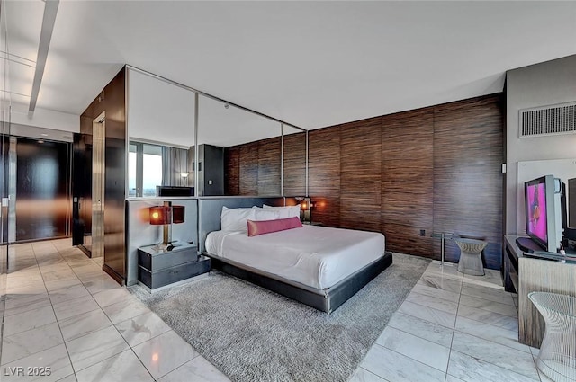 bedroom with visible vents, elevator, wooden walls, and marble finish floor