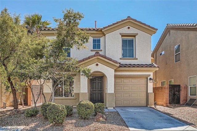 mediterranean / spanish-style home with fence, driveway, stucco siding, a garage, and a tiled roof