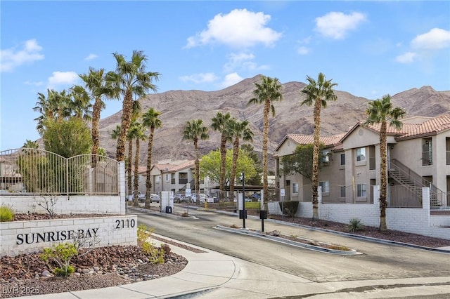 exterior space featuring a gated entry, a residential view, curbs, sidewalks, and a mountain view