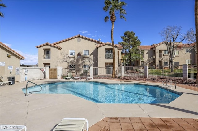 community pool featuring a patio and fence