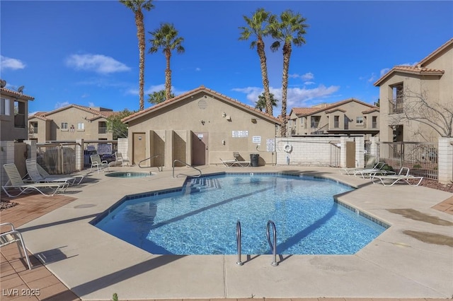 pool featuring a patio, fence, and a residential view