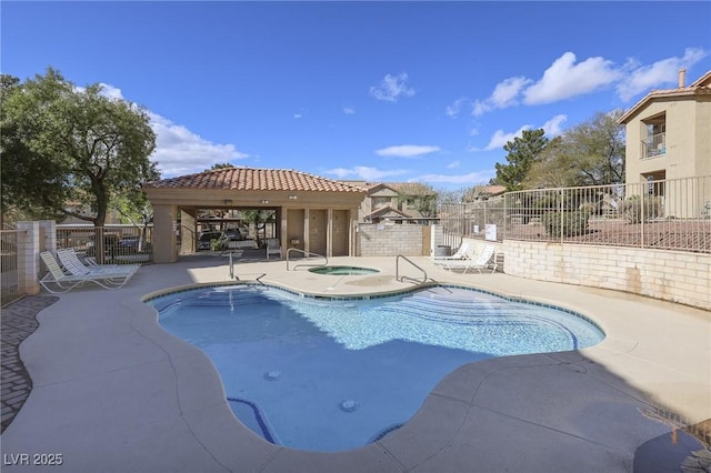 pool featuring a patio, fence, and a hot tub