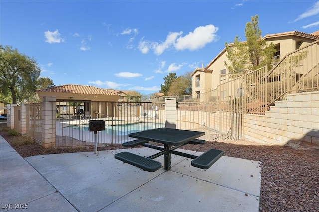 exterior space with a patio area, a pool, and fence