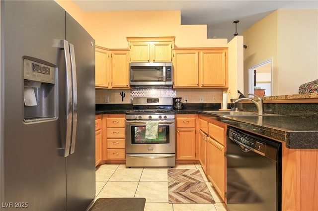 kitchen with dark countertops, backsplash, light tile patterned floors, stainless steel appliances, and a sink