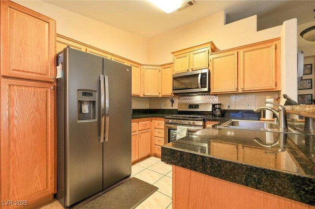 kitchen featuring visible vents, backsplash, light tile patterned floors, stainless steel appliances, and a sink