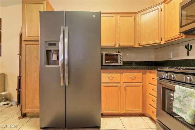 kitchen featuring decorative backsplash, a toaster, light tile patterned floors, and appliances with stainless steel finishes