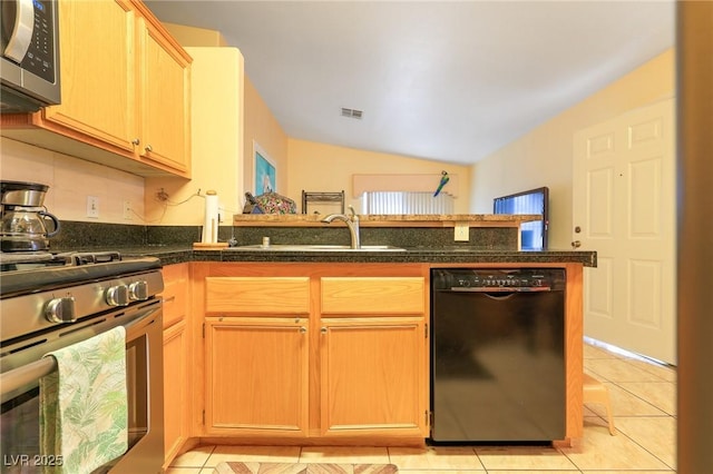 kitchen with a sink, appliances with stainless steel finishes, a peninsula, light tile patterned floors, and vaulted ceiling