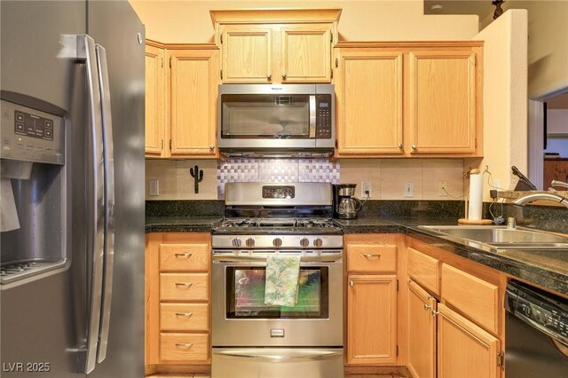 kitchen with tasteful backsplash, appliances with stainless steel finishes, and a sink