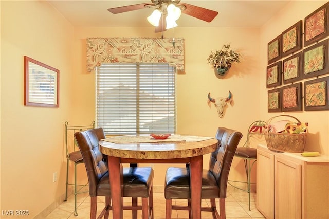 dining room featuring light tile patterned floors, a ceiling fan, and baseboards