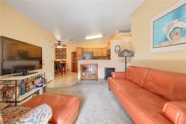 living area featuring lofted ceiling, light tile patterned flooring, light colored carpet, and ceiling fan