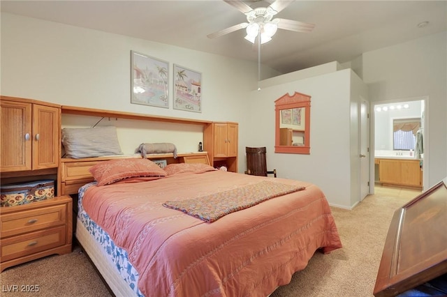 bedroom featuring light carpet, a ceiling fan, and ensuite bathroom