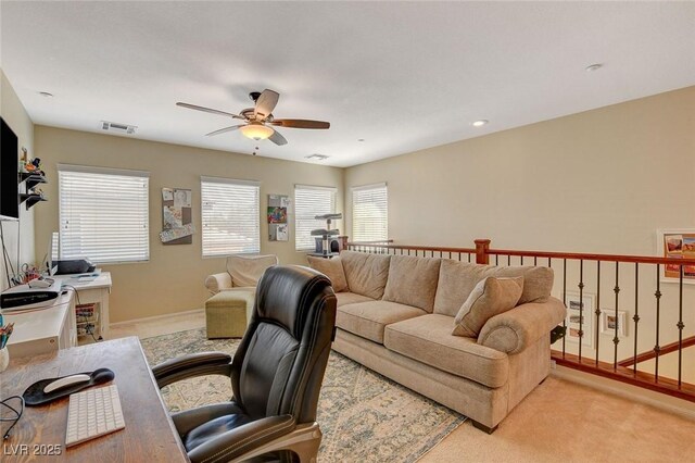 carpeted office space with visible vents, baseboards, and a ceiling fan