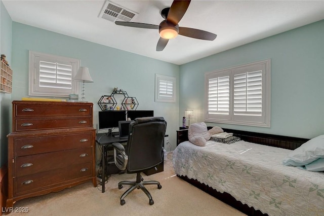 bedroom with visible vents, light colored carpet, and a ceiling fan