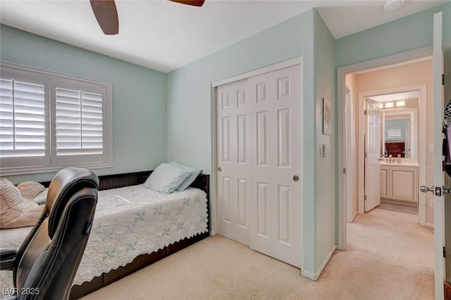 bedroom featuring a closet, light colored carpet, baseboards, and a ceiling fan