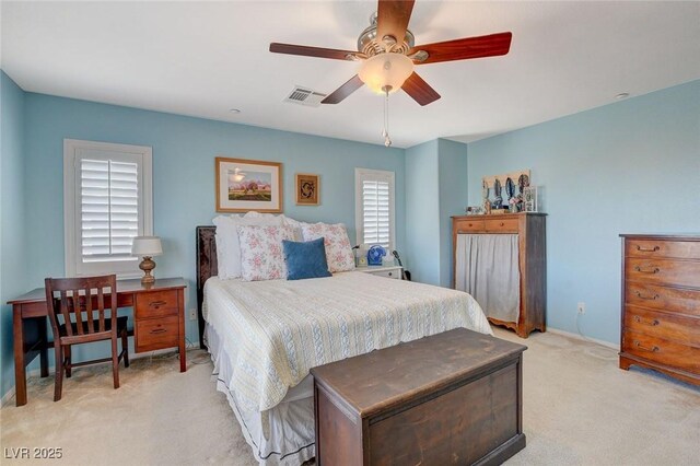 bedroom with visible vents, light colored carpet, and ceiling fan