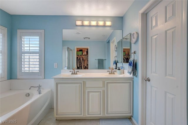 bathroom featuring visible vents, a shower stall, double vanity, a bath, and a sink