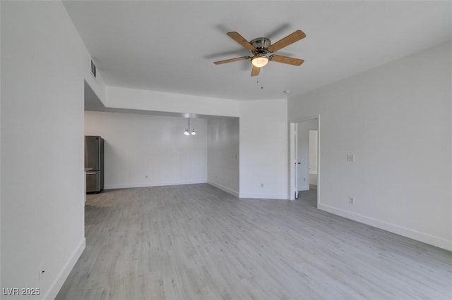 empty room with visible vents, baseboards, ceiling fan, and wood finished floors