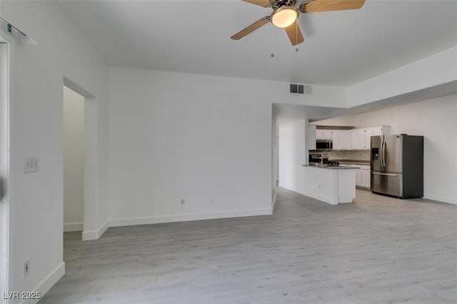 unfurnished living room with light wood finished floors, visible vents, baseboards, and a ceiling fan