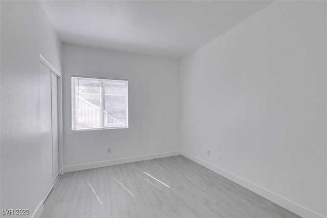 empty room featuring baseboards and wood finished floors