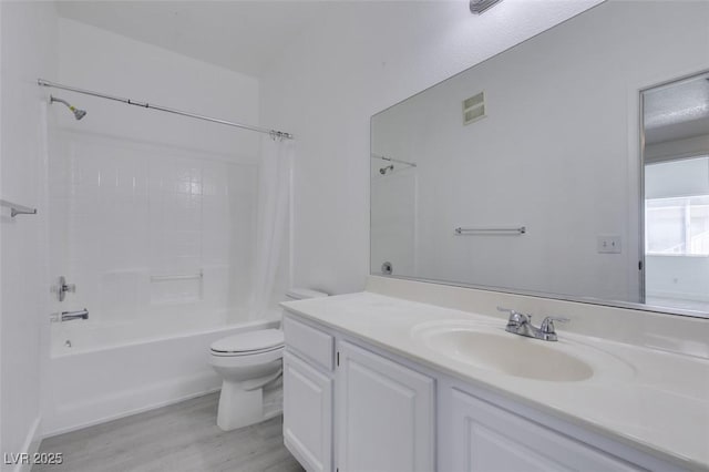 full bathroom with visible vents, toilet, wood finished floors, shower / bath combination with curtain, and vanity