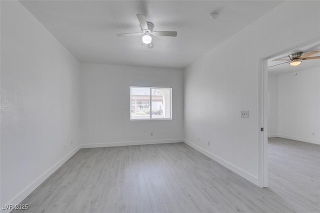 empty room with baseboards, a ceiling fan, and light wood finished floors