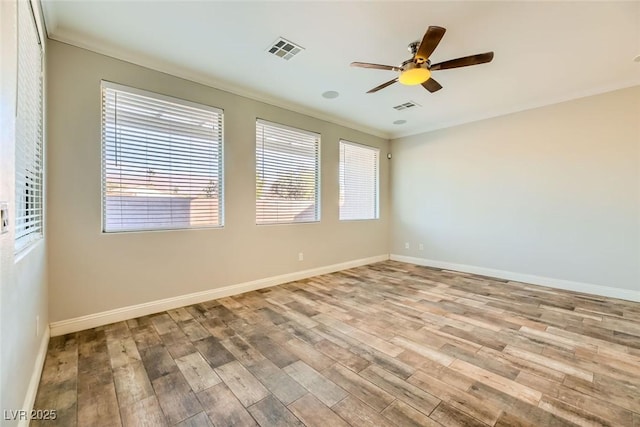 spare room featuring a ceiling fan, wood finished floors, visible vents, and baseboards