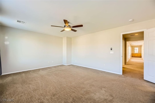 unfurnished room with visible vents, baseboards, carpet, and a ceiling fan