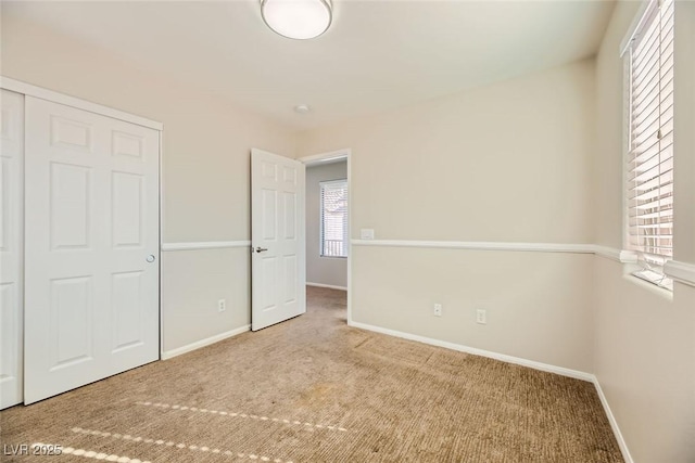 unfurnished bedroom with carpet, baseboards, and a closet