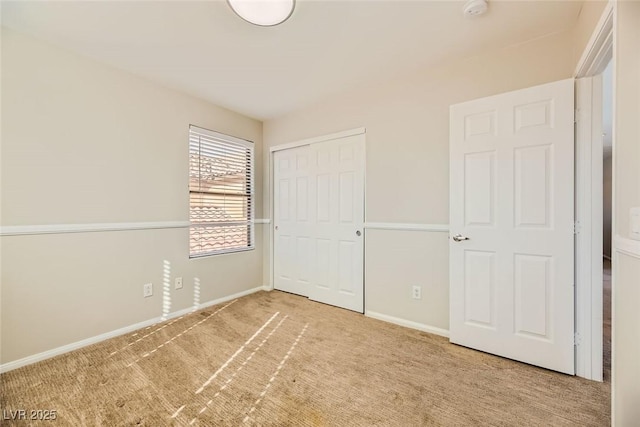 unfurnished bedroom featuring a closet, baseboards, and carpet floors