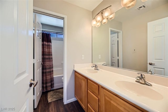 full bath with double vanity, visible vents, wood finished floors, and a sink