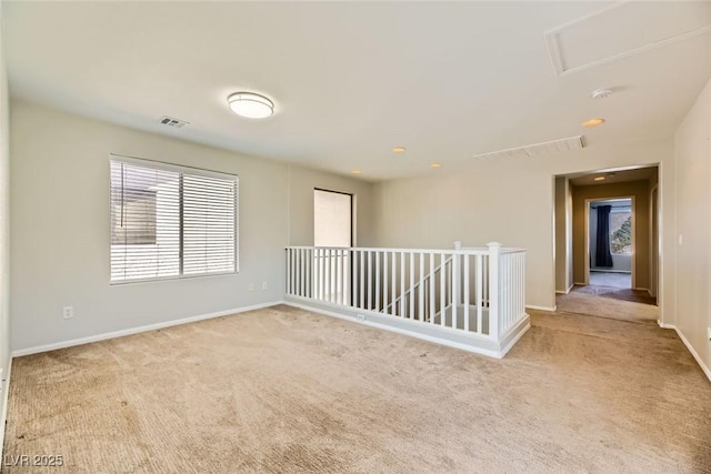 empty room with visible vents, carpet, and baseboards