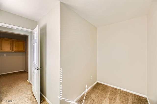 hallway featuring light carpet and baseboards