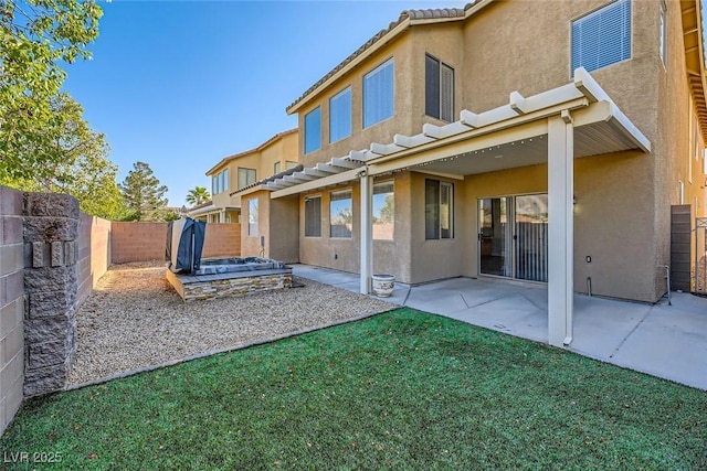 rear view of property featuring a fenced backyard, stucco siding, a tiled roof, and a patio