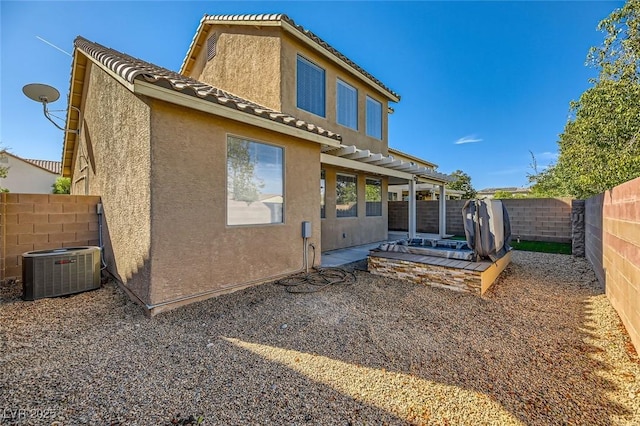 rear view of house featuring a patio, a fenced backyard, central AC, stucco siding, and a tiled roof