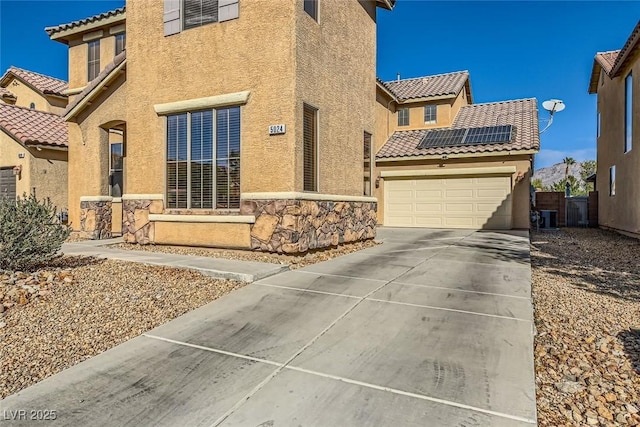 exterior space with stucco siding, central AC unit, solar panels, and a tile roof