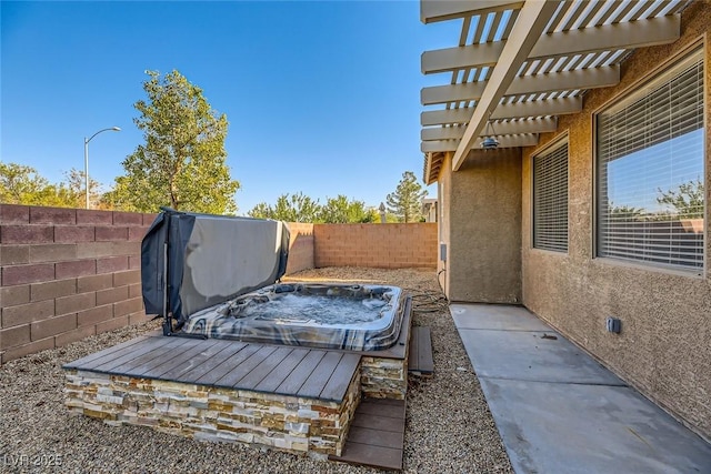 view of yard featuring a fenced backyard, a covered hot tub, and a pergola