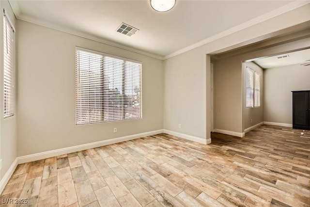 unfurnished room featuring visible vents, baseboards, wood finished floors, and ornamental molding